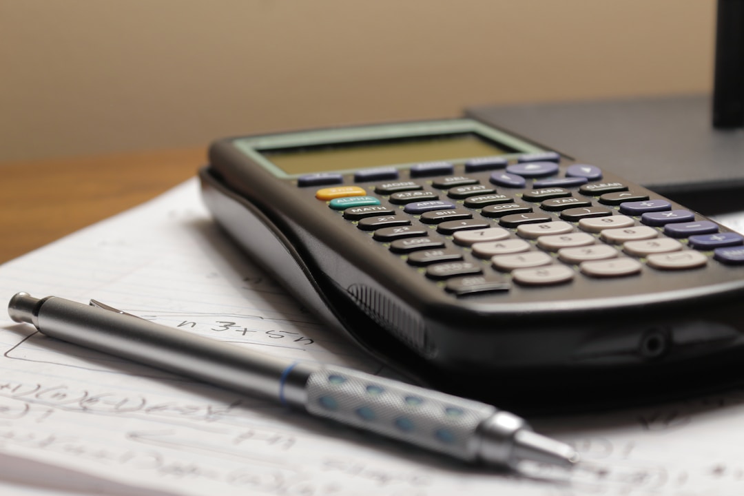 Calculator and financial paperwork on a desk for reviewing employee equity compensation.